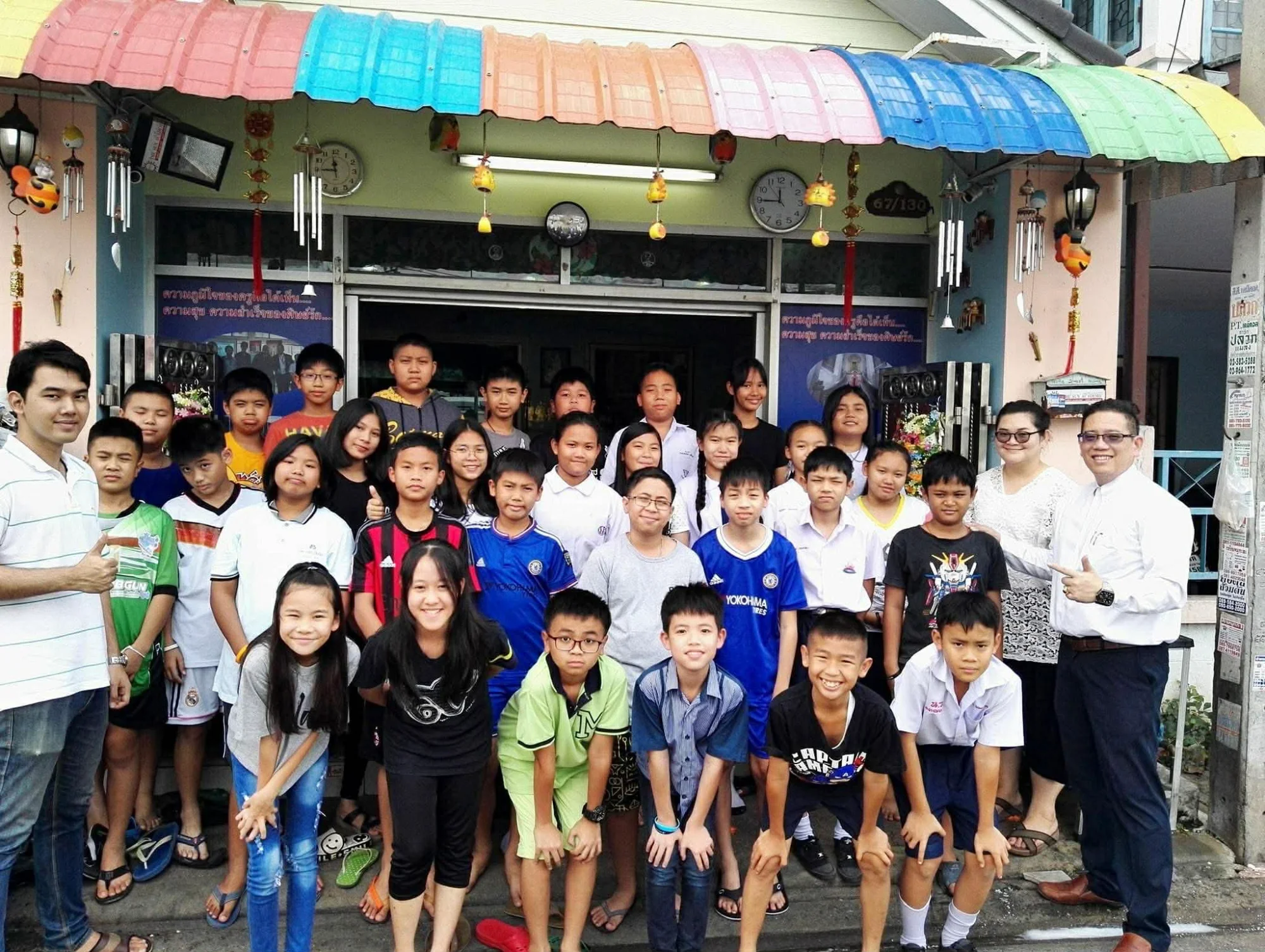 นักเรียนและครูถ่ายรูปหน้าสถาบัน